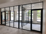 Glass offices with glass sidewalls and black frame color field-fit demountable walls #1640