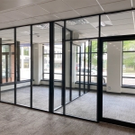 Glass offices with glass sidewalls and black frame color field-fit demountable walls #1640