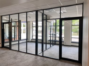 Glass offices with glass sidewalls and black frame color field-fit demountable walls #1640
